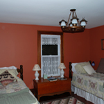 2 single beds, morning light, view of the ponds and a wagon wheel light fixture. Guess who the pioneers in the picture are.